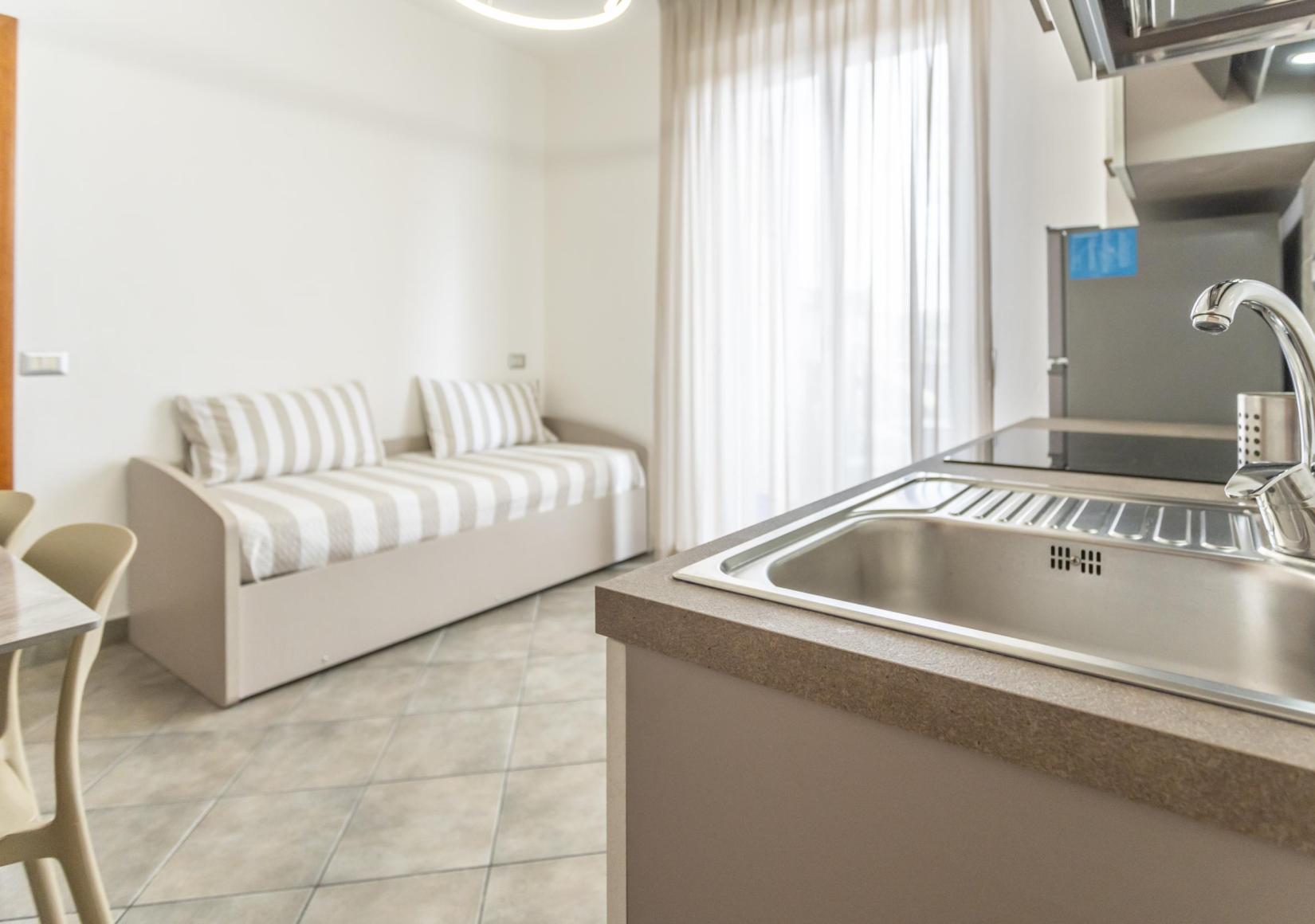 Modern kitchen with a sofa bed and dining table.