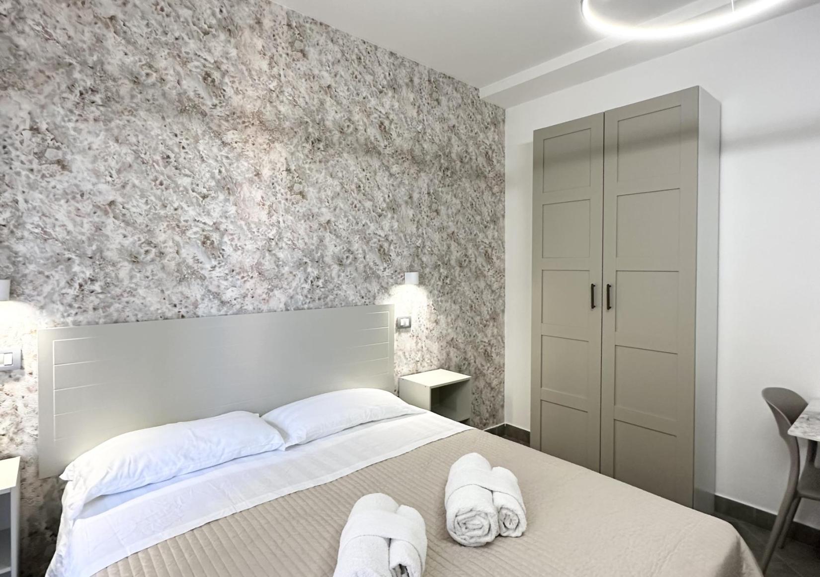 Modern room with a double bed, wardrobe, and elegant lighting.